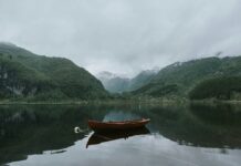 명상의 힘, 마음과 몸을 건강하게 유지하는 비밀 brown boat on body of water near green mountains under white sky at daytime
