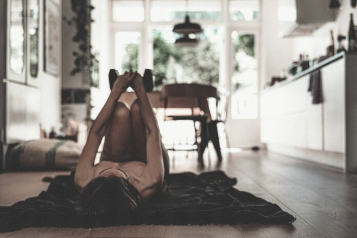 a woman laying on the floor in a kitchen