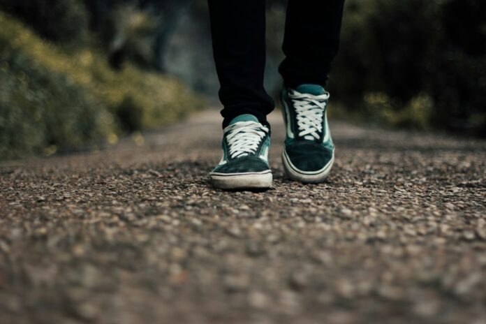 a person standing on a gravel road with their shoes on
