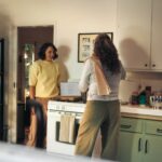 바쁜 일상 속 ‘마음 챙김 루틴’…현대인 건강 관리의 새로운 열쇠 Two women talking in a kitchen while cooking